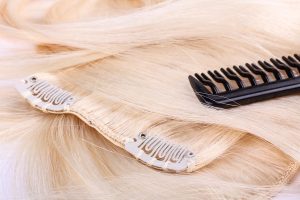 Hair extensions clips and black brush, closeup